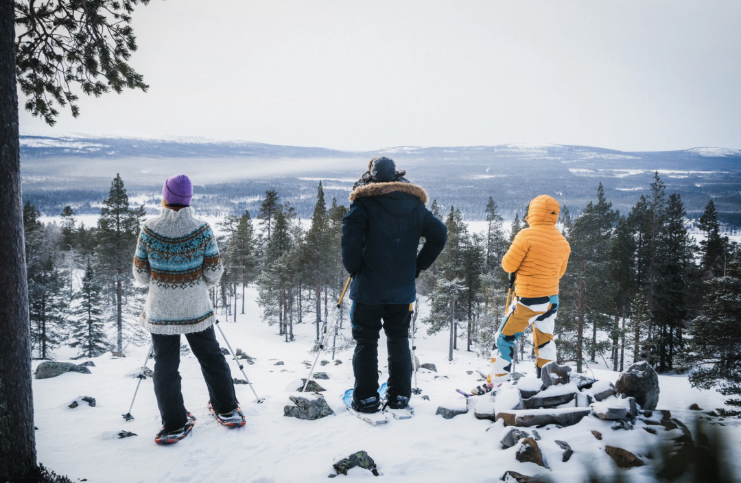 Three people on snowshoes on an early winter day on top of fell Soutaja