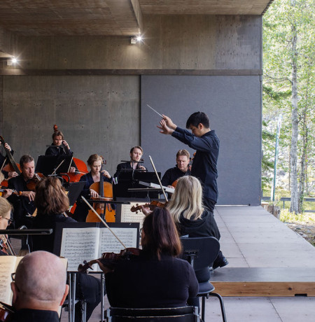 Orkesteri soittaa ulkoilmalavalla Luostolla