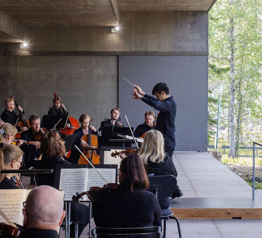 Orkesteri soittaa ulkoilmalavalla Luostolla